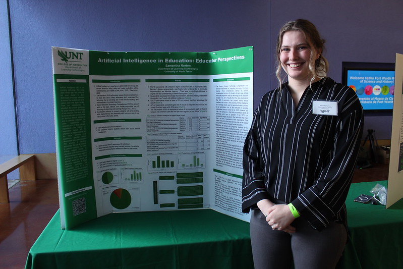 Student posing with their presentation poster.